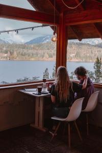 圣卡洛斯-德巴里洛切半岛贝提酒店的两名妇女坐在桌子上,享有湖景