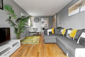 斯凯尔默斯代尔Sandy Lane Apartment的客厅配有灰色的沙发和电视