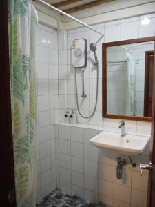 大城Banmai87 Guest House บ้านไม้87 เกสต์เฮ้าส์的一间带水槽、淋浴和镜子的浴室