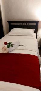 安曼Tamrah Suites Hotel的一张红色和白色的床,上面有帽子