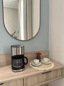 利雅德Modern Appartements With Private Entry的咖啡壶和一张桌子上的两个杯子及镜子