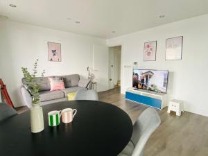 伦敦Morden 2bed2bath London Zone2 City/River View Home的客厅配有桌子和沙发