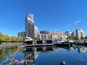 伦敦Morden 2bed2bath London Zone2 City/River View Home的城市天际线,水中拥有建筑和船只