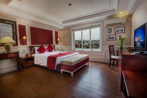 河内美的河内酒店的一间卧室配有一张床、一张书桌和一台电视