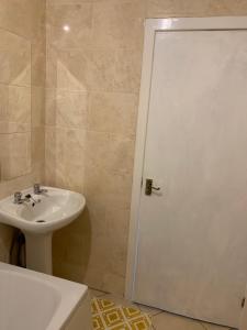 阿什顿下安林恩New 2 bedroom Apartment in Greater Manchester的一间带水槽和白色淋浴门的浴室