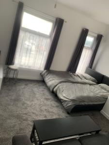 阿什顿下安林恩New 2 bedroom Apartment in Greater Manchester的一间卧室设有一张床和两个窗户。