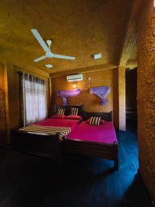 汉班托塔Bundala Flamingo Cotteges的一间卧室设有两张床和天花板