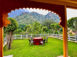 乌代浦Udai Valley Resort- Top Rated Resort in Udaipur with mountain view的山地庭院里的桌椅