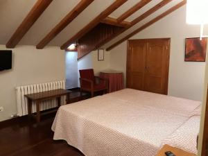 贝纳斯克阿拉奎埃斯酒店的卧室配有一张床和一张桌子及椅子