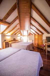 贝纳斯克阿拉奎埃斯酒店的大客房设有两张带木制天花板的床。