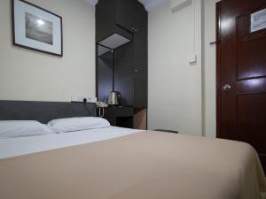新加坡Amrise Hotel, Check in at 10PM, Check out at 9AM的卧室配有白色的床和棕色的门。