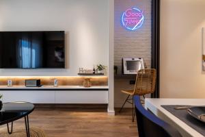 克桑西Good times - Luxury Studio Apartments的客房设有书桌和墙上的电视