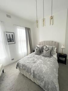 贝尔法斯特Luxury Belfast Stay - Townhouse的白色卧室配有带枕头的大床