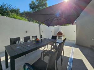 杜布罗夫尼克Villa Olivila的庭院内一张带遮阳伞的餐桌