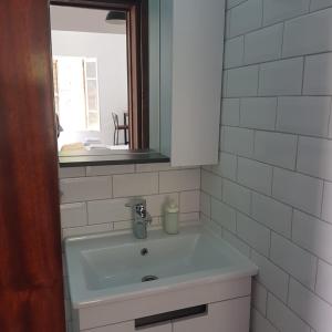 北尼科西亚Sabor Residence的一间带镜子和窗户的盥洗盆的浴室