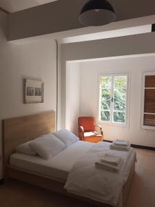 北尼科西亚Sabor Residence的一间卧室配有一张带椅子的床和一扇窗户