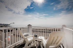 汉普顿大西洋汽车旅馆的两把白色椅子坐在俯瞰着大海的阳台