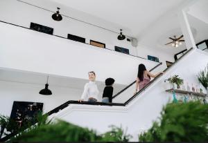 清莱The Courtyard Chiangrai的三人坐在房子的楼梯上