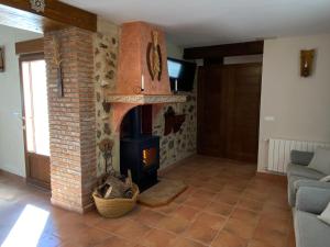 San AgustínCasa Rural El Aljibe的客厅设有砖砌壁炉和沙发。