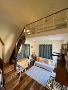 爱妮岛Luxury Tiny Home with Free* Use of Tiny Car的客厅配有高架床和沙发