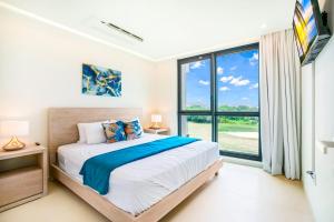 CupecoyLuxury Oceanview 1BR on beach的一间卧室设有一张床和一个大窗户