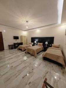 瓦迪穆萨iHome Petra的配有两张床的大客房,铺有大理石地板