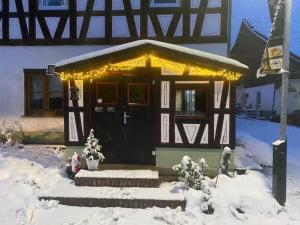 WelzheimFerien auf dem Eliesenhof的雪中灯的房子