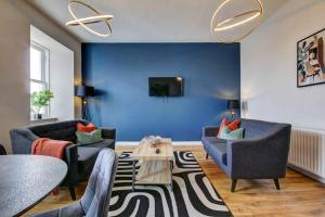 欧文The Irvine - Coorie Doon Apartments的客厅配有两把椅子和蓝色的墙壁