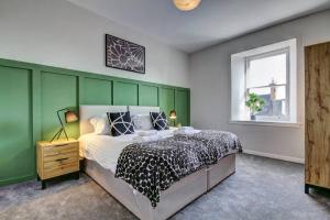 欧文The Irvine - Coorie Doon Apartments的一间卧室设有一张床和绿色的墙壁