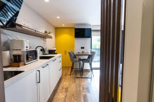 马拉加Apartments DREAM的厨房配有白色橱柜和黄色墙