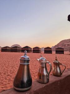 瓦迪拉姆Star City Camp wadirum的两个茶壶坐在沙滩上的桌子上