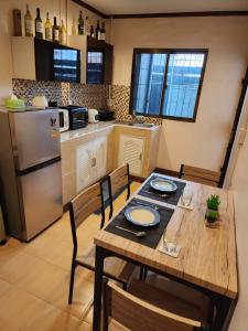 曼谷The Travellers House - Pet Friendly Accommodation的厨房配有木桌、椅子和冰箱
