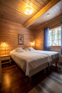 Savonranta洛玛沃提度假屋的木制客房内的一间卧室配有一张大床