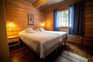 Savonranta洛玛沃提度假屋的小木屋内一间卧室,配有一张床