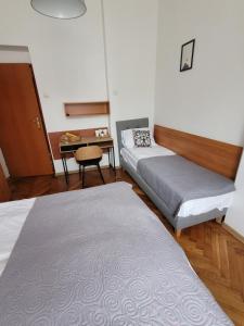 克雷尼察Zajazd Meran的客房设有两张床、一张桌子和一张书桌。