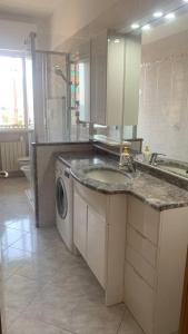 瓦拉泽Vista mare con ogni comfort的厨房配有水槽和洗衣机