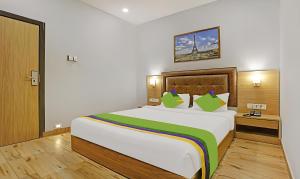孟买ZARA GRAND HOTEL的卧室配有带绿色枕头的大型白色床
