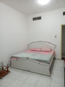 沙迦Holiday Home 2 Bedrooms Apartment for Family Only的白色客房内的白色床,配有粉红色枕头
