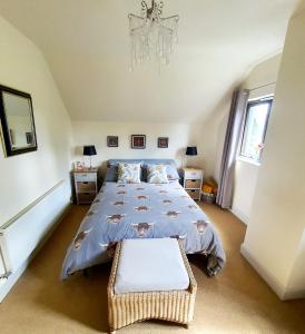 托明陶尔Self catering accommodation three bedroom house or one bedroom cottage的一间卧室配有一张大床和一个吊灯。