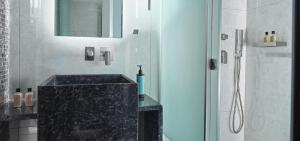 罗希姆诺Nautilux Rethymno by Mage Hotels的一间带黑色水槽和淋浴的浴室