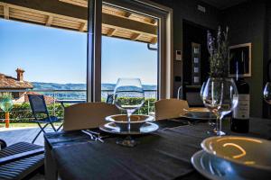 瓜热讷Vista Langhe - CerratoHouses的享有美景的餐桌,配有酒杯