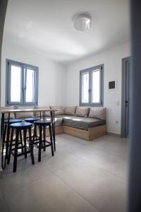 斯基罗斯岛Kotinos Luxury Suites的客厅配有沙发、桌子和窗户