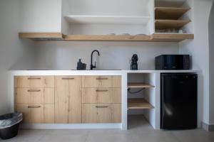 斯基罗斯岛Kotinos Luxury Suites的厨房配有白色柜台和黑色冰箱。