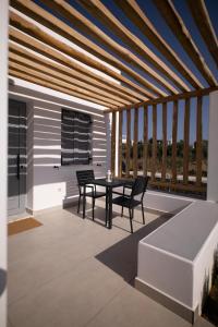 斯基罗斯岛Kotinos Luxury Suites的一个带桌椅的庭院和一个阳台