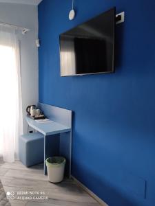 庞特卡格纳诺Hotel Calypso的一间设有一张桌子和镜子的蓝色墙壁客房