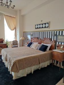 埃尔莫波利斯Locadiera Pansion的一间卧室配有一张大床和木制床头板