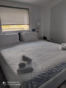 庞特卡格纳诺Hotel Calypso的一张白色的床,上面有毛巾,还有窗户
