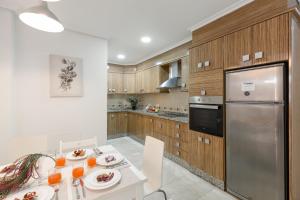 瓜尔达马尔·德尔·塞古拉Fidalsa Enjoy Life的厨房配有桌子和不锈钢冰箱。