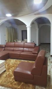 弗里敦Victorus Homes的客厅配有棕色皮沙发和桌子