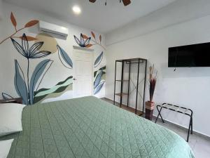 阿卡普尔科Residencial Gran Palma的一间卧室配有一张带壁画的绿色床
